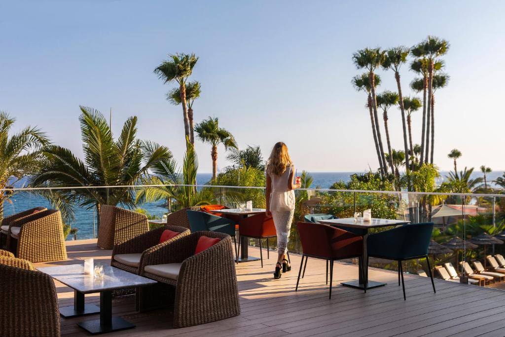 a woman standing on a deck at a resort at Amathus Beach Hotel Limassol in Limassol
