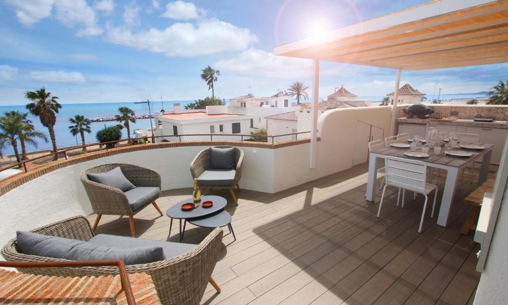 balcón con mesa, sillas y vistas al océano en Casa Acacia Mar, en Cambrils