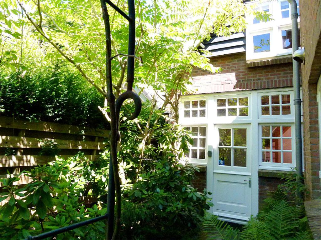 a house with a blue door in the yard at 't Kasteeltje in Bergen