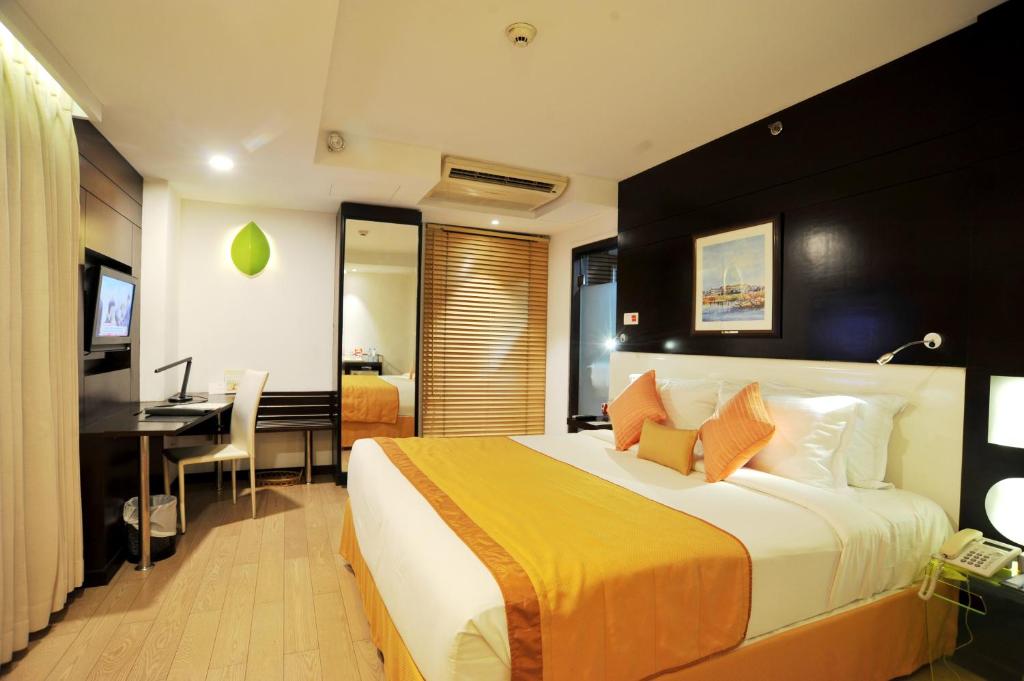 a hotel room with a large bed and a desk at Platinum Residence in Dhaka