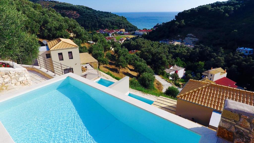a blue swimming pool with a view of a mountain at Asaya Hills Villas in Parga