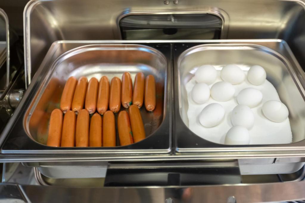 a tray of hot dogs and eggs in a toaster oven at Aksent Hotel in Baku