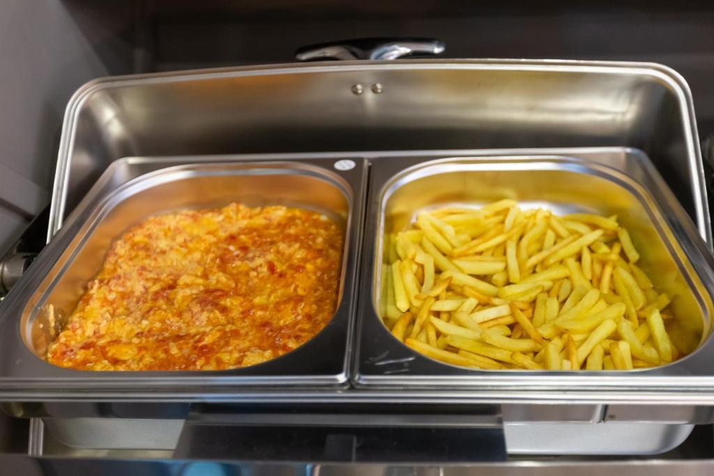 two trays of food with pasta in a tray at Aksent Hotel in Baku