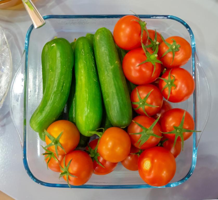 a container of cucumbers and tomatoes on a table at Aksent Hotel in Baku