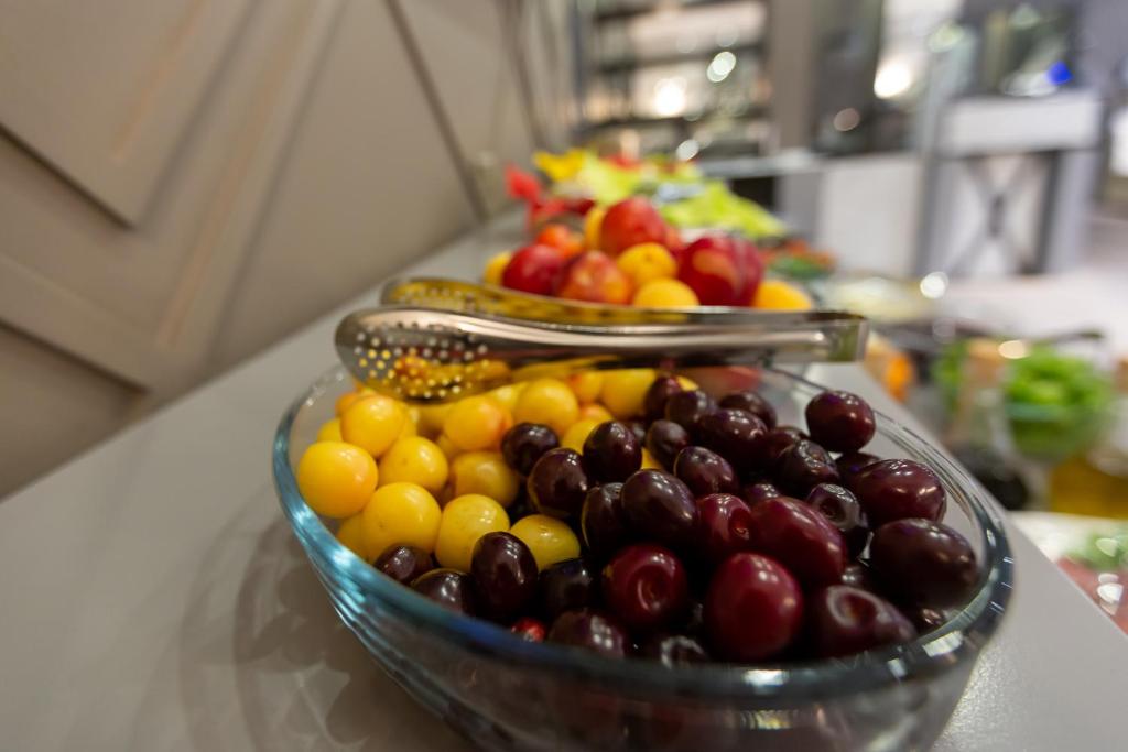 a glass bowl filled with different types of fruits on a counter at Aksent Hotel in Baku