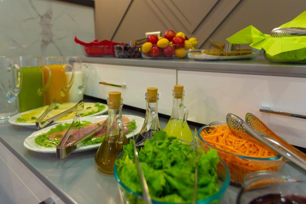 a counter with plates of food and bottles of wine at Aksent Hotel in Baku