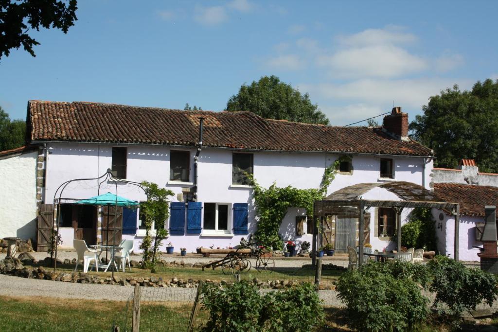 una antigua casa blanca con cenador en La Metairie, en Parthenay