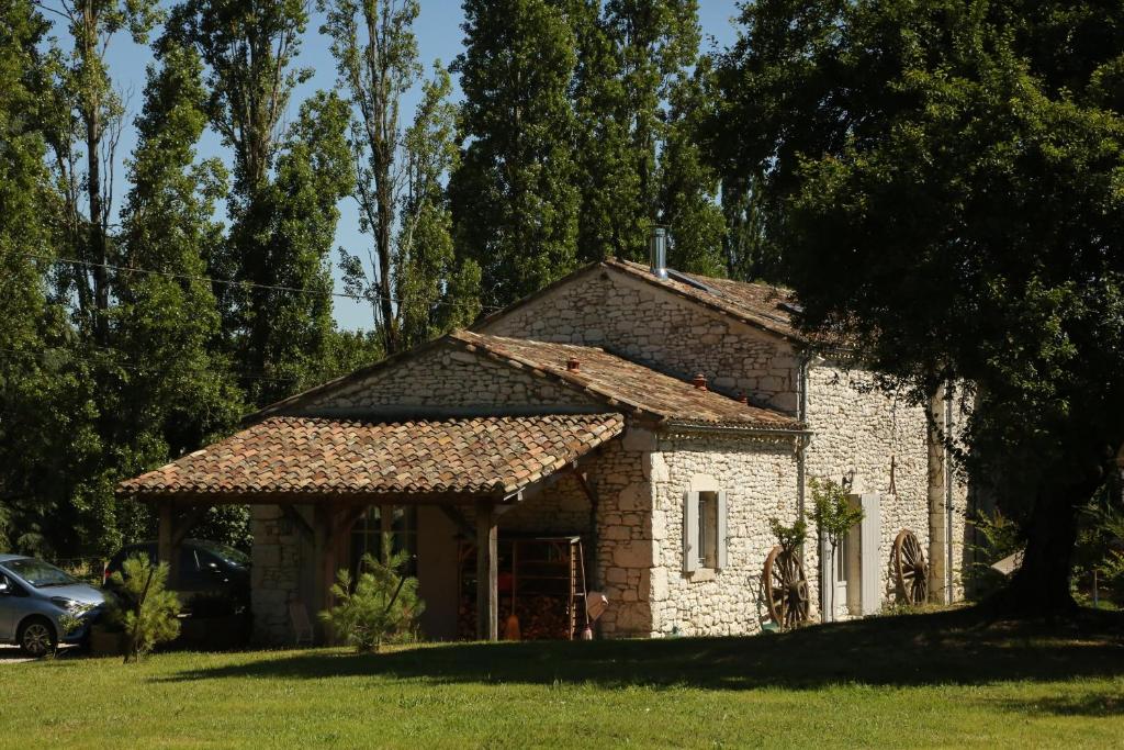 uma casa de pedra num campo com uma árvore em Chemin de Gargamelle Gite 'Mirabelle' em Ligueux