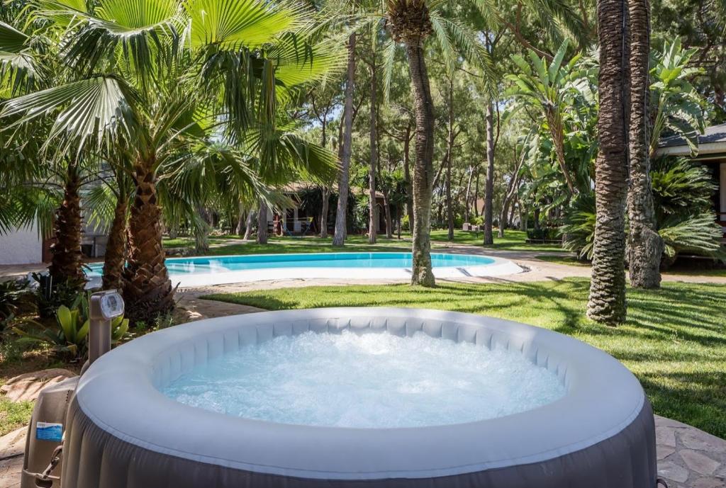 una bañera de hidromasaje en un patio con palmeras en El Oasis Villa Resort en La Eliana