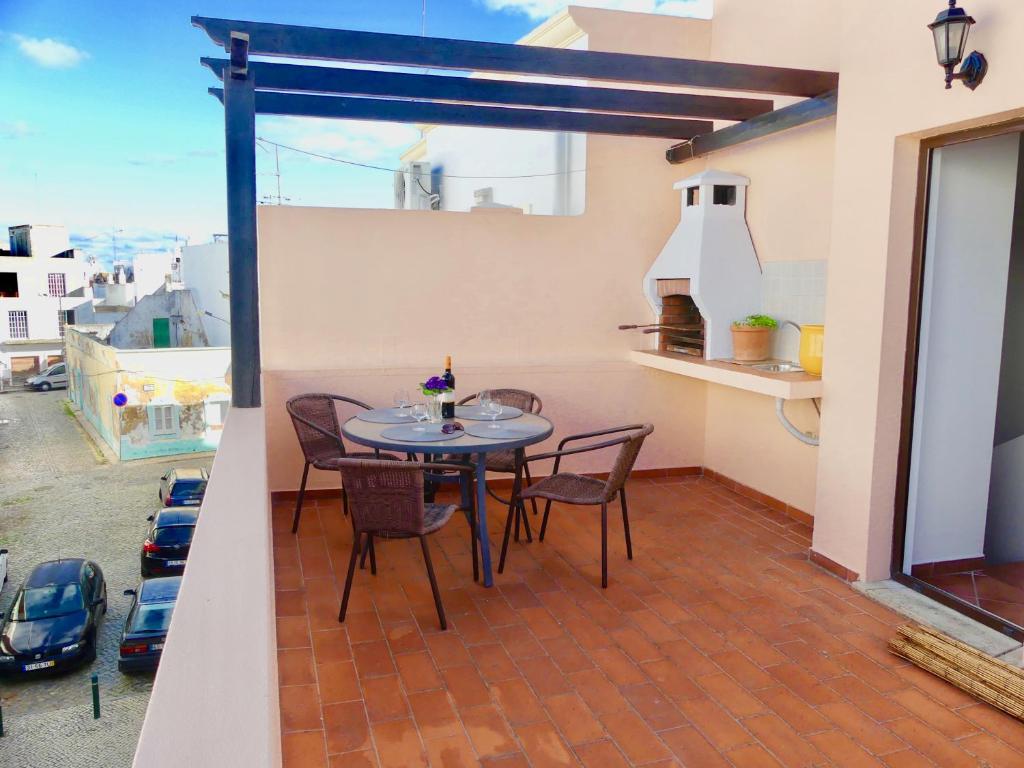 patio con mesa y sillas en el balcón en Kasa Sunshine, en Olhão