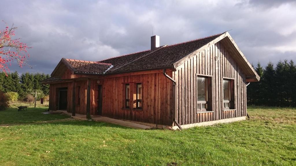 una pequeña casa de madera sentada en un campo en Kasteheina kodu, en Voka