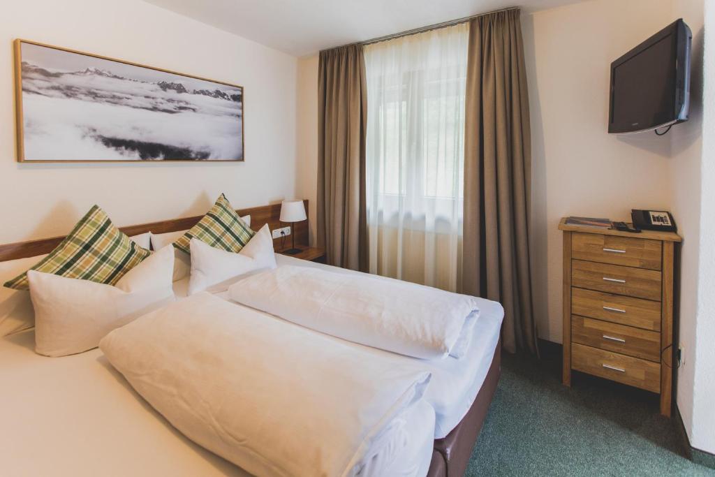 a hotel room with a bed and a television at Hotel Montfort in Sankt Anton am Arlberg