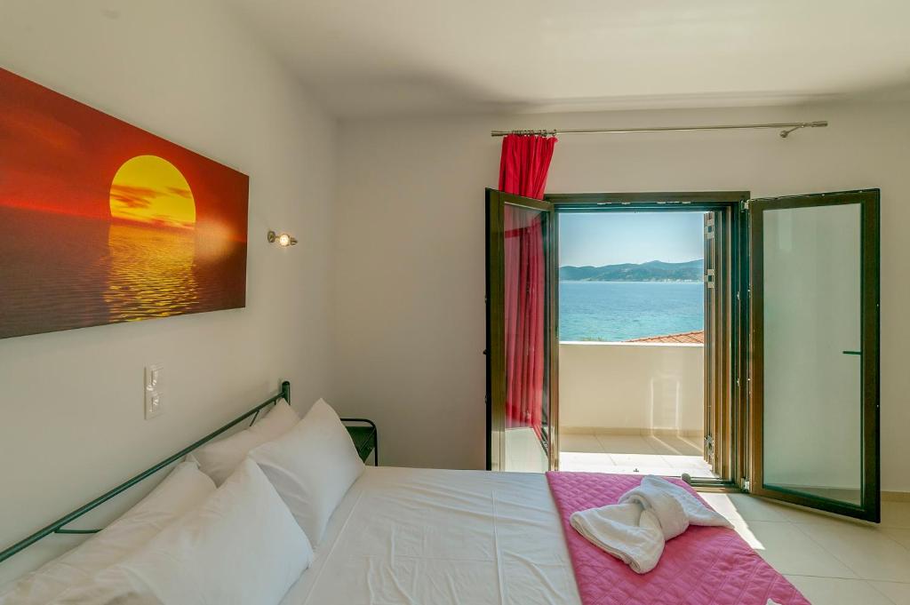a bedroom with a bed with a view of the ocean at Spela House in Agioi Apostoli