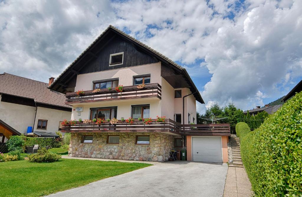 a house with a black roof and a garage at Apartments and Rooms Banić in Kranjska Gora