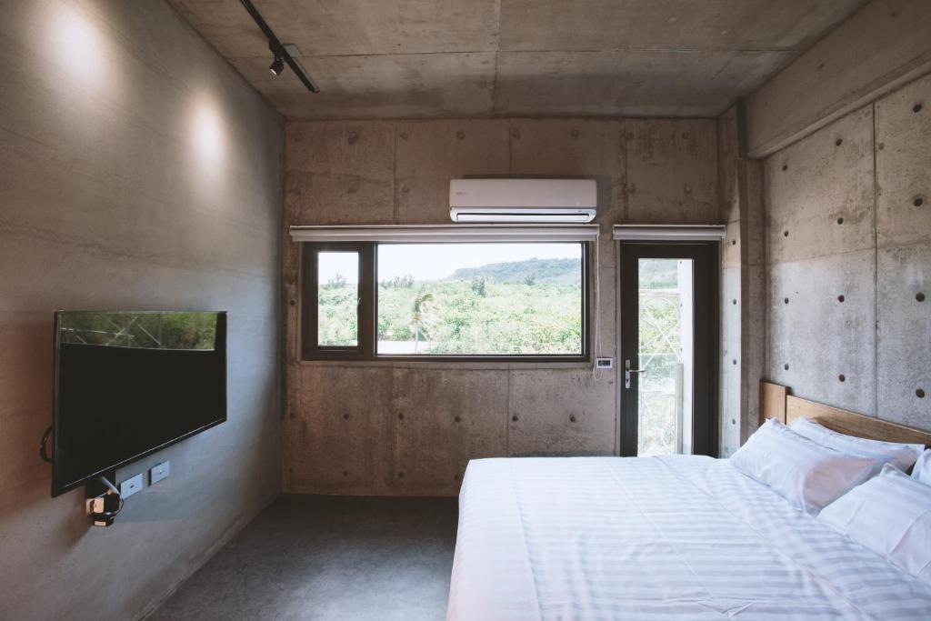 a bedroom with a bed and a flat screen tv at 墾丁 住在Zhuzai in Checheng