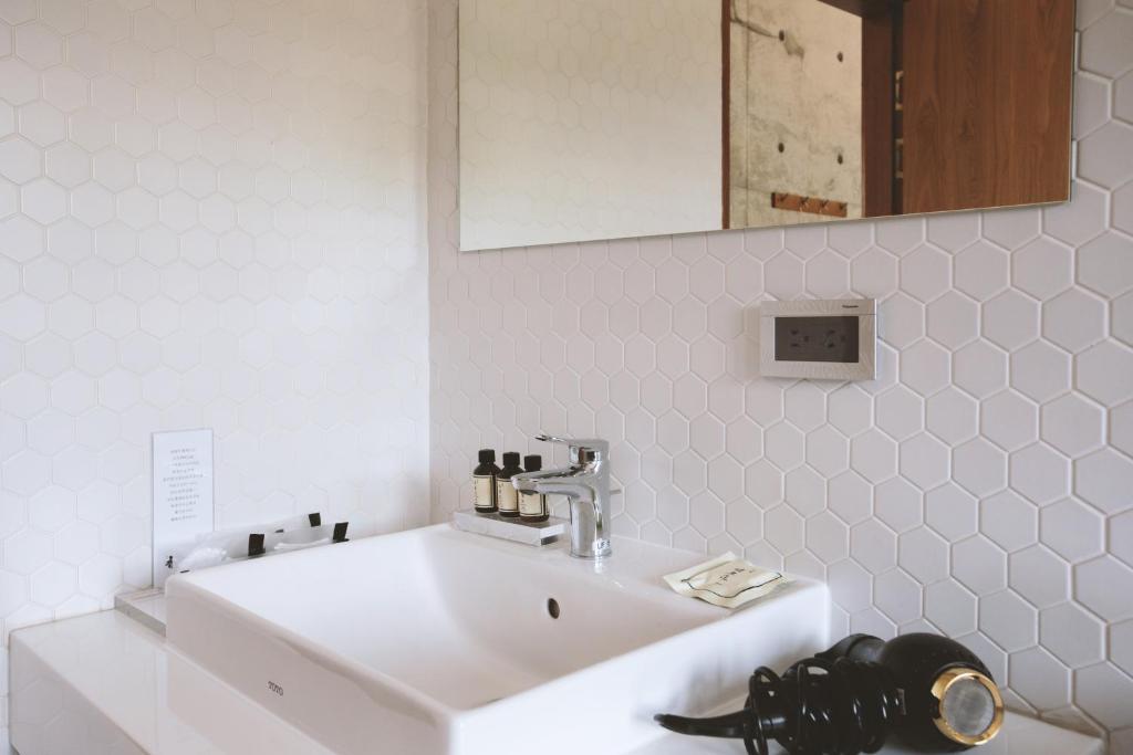 a white sink in a bathroom with a mirror at 墾丁 住在Zhuzai in Checheng
