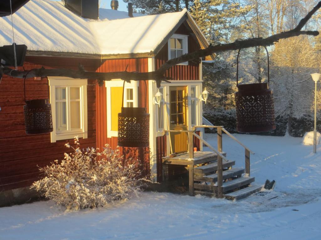 a small house with a porch in the snow at Myllyn Pirtti Cottage in Naamijoki