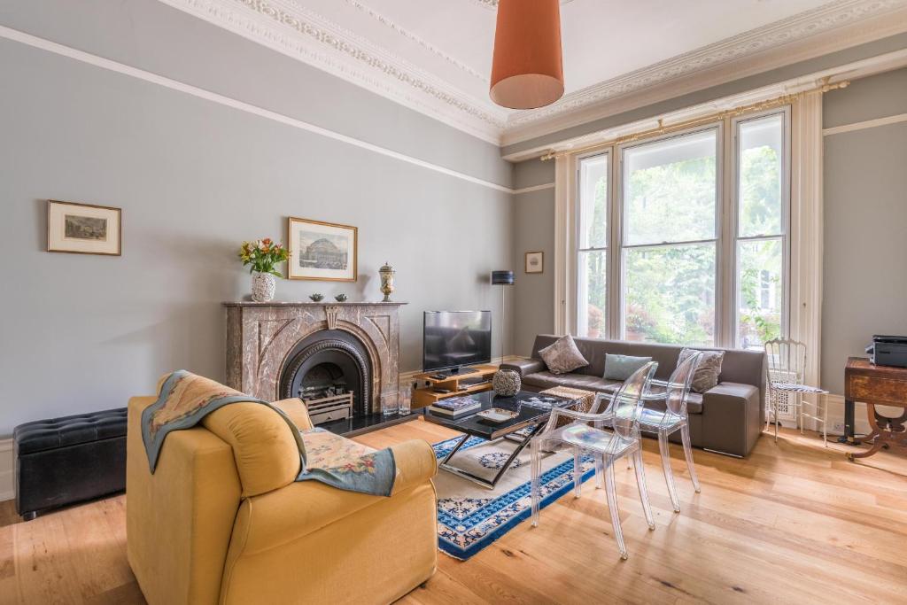 - un salon avec un canapé et une cheminée dans l'établissement Lovely Chelsea Home near The Thames by UndertheDoormat, à Londres