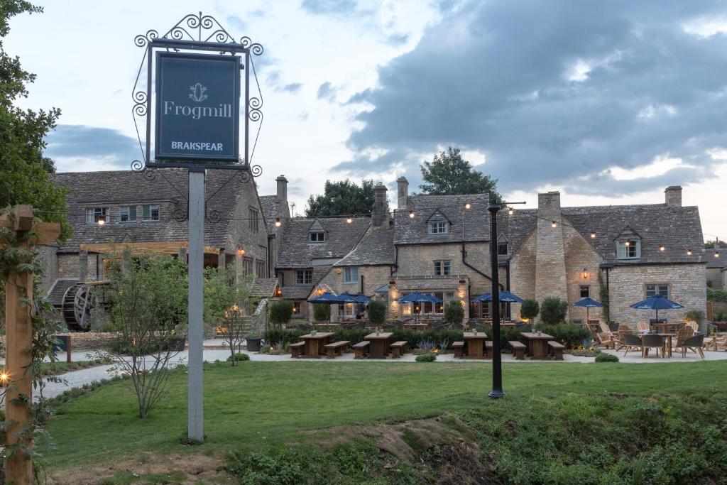 un panneau devant un bâtiment avec une cour dans l'établissement The Frogmill Hotel, à Cheltenham