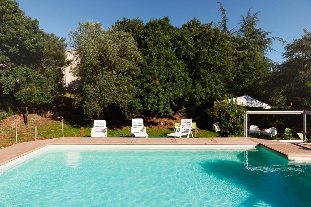 a swimming pool with two lawn chairs and two lawn chairs at Per - Il Parco Dell'Energia Rinnovabile in Collicello