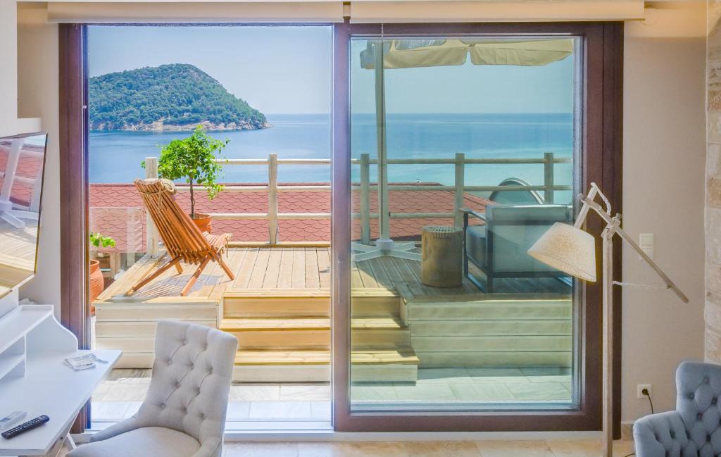 a room with a sliding glass door with a view of the ocean at Agorastos Suites in Kinira