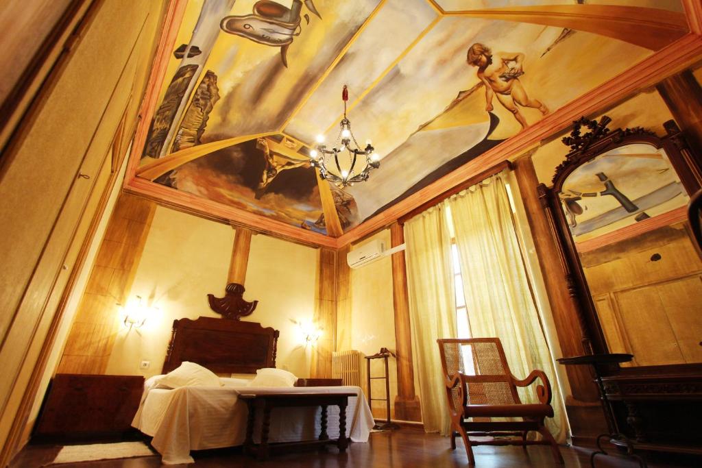 a bedroom with a bed and a painting on the wall at Santa Ana B&B in Darnius