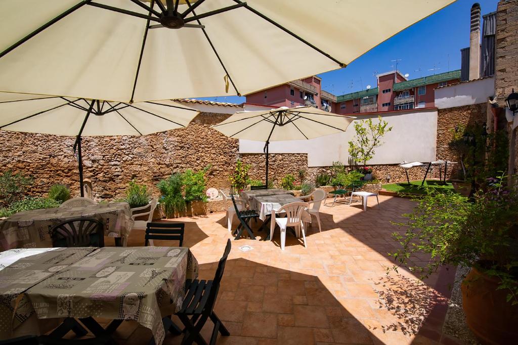 a patio with tables and chairs and umbrellas at B&B ARCHIMEDE in Floridia