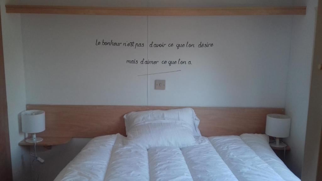 a bedroom with a bed with a sign on the wall at Chambres d'Hotes Elvire et Laurent Barbey in Sainte-Marie-du-Mont