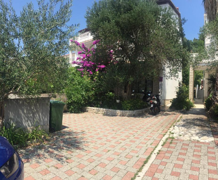 a brick driveway in front of a house with a tree at Apartments Matušan in Rab