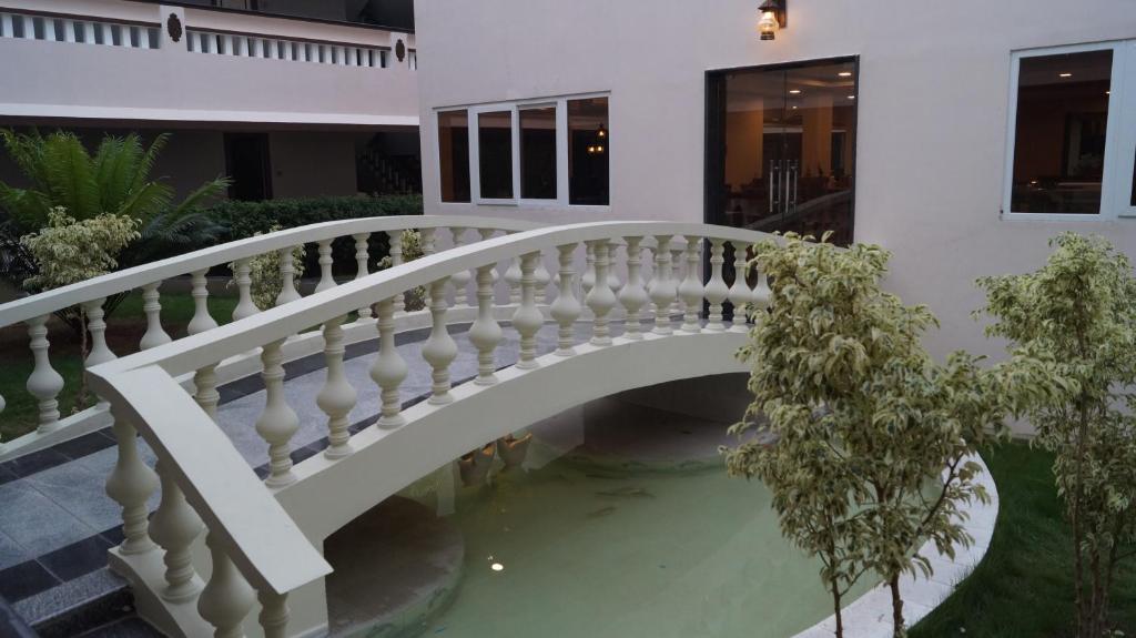 a bridge over a pond in a house at Athena Hotel in Tiruvannāmalai