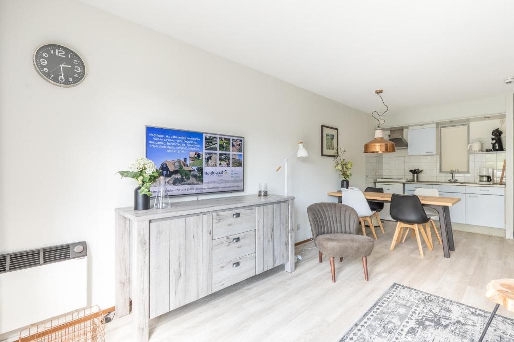 a kitchen and living room with a tv on a cabinet at Appartement De Parel, Resort Amelander Kaap in Hollum