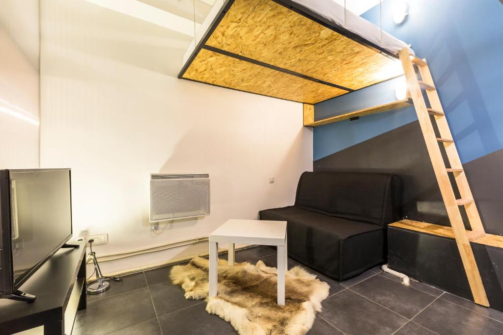 パリにあるPretty 25 m2 in a lively districtの二段ベッド1組、椅子、テレビが備わる客室です。
