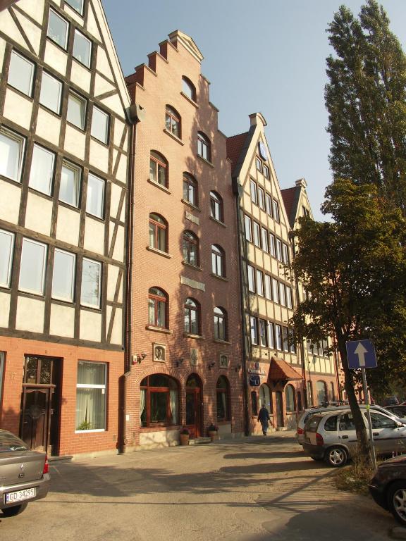 eine Gruppe von Gebäuden in einer Stadtstraße mit Autos in der Unterkunft Willa Biala Lilia Old Town in Danzig
