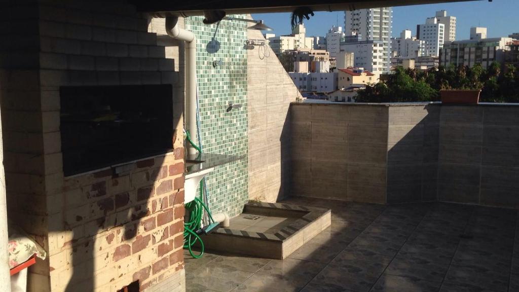 uma parede de tijolos com um banco na lateral de um edifício em Cobertura Praia do Morro em Guarapari