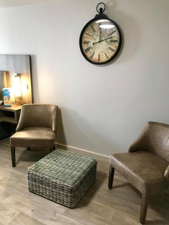 a room with two chairs and a clock on the wall at The Anchor Hotel & Bars in Ingoldmells