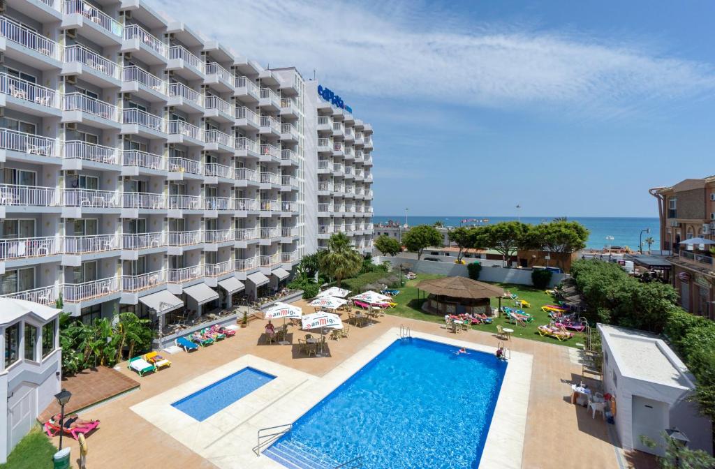 
a beach with a pool and a large building at Medplaya Hotel Balmoral in Benalmádena
