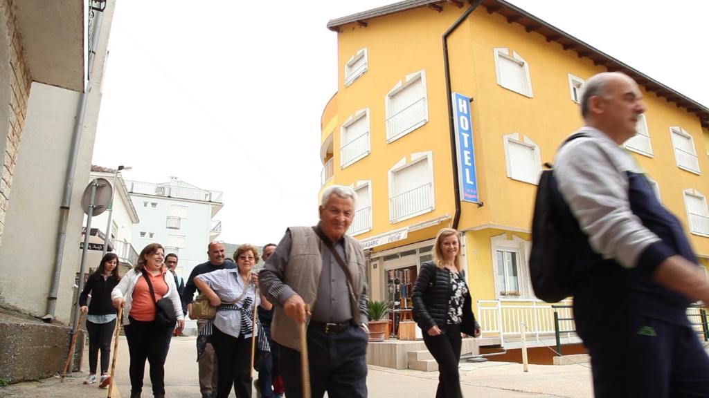 a group of people walking down a street at Hotel Bagarić -ispod brda ukazanja adress Kraljice Mira 56 Bijakovci Međugorje in Međugorje