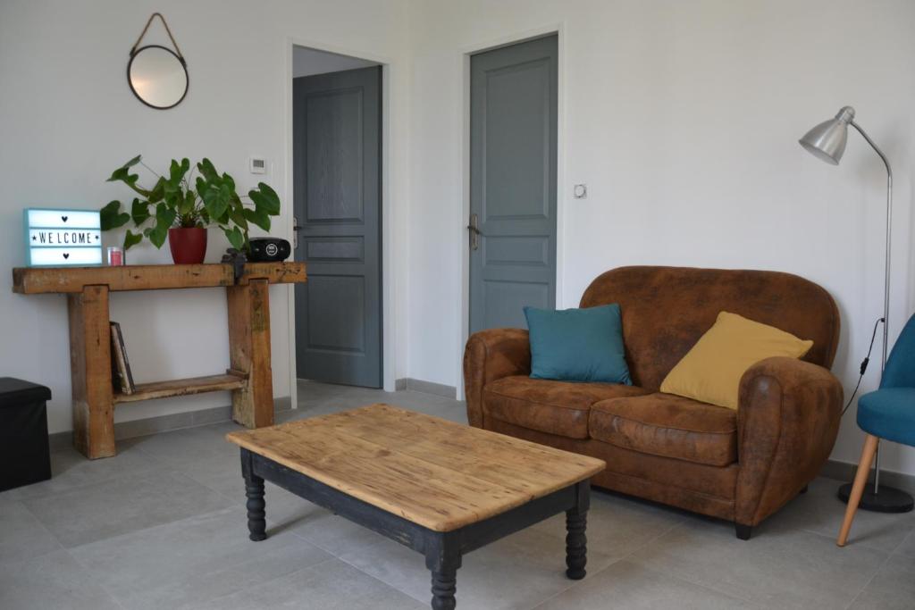 a living room with a couch and a coffee table at Le Cottage in Harbonnières