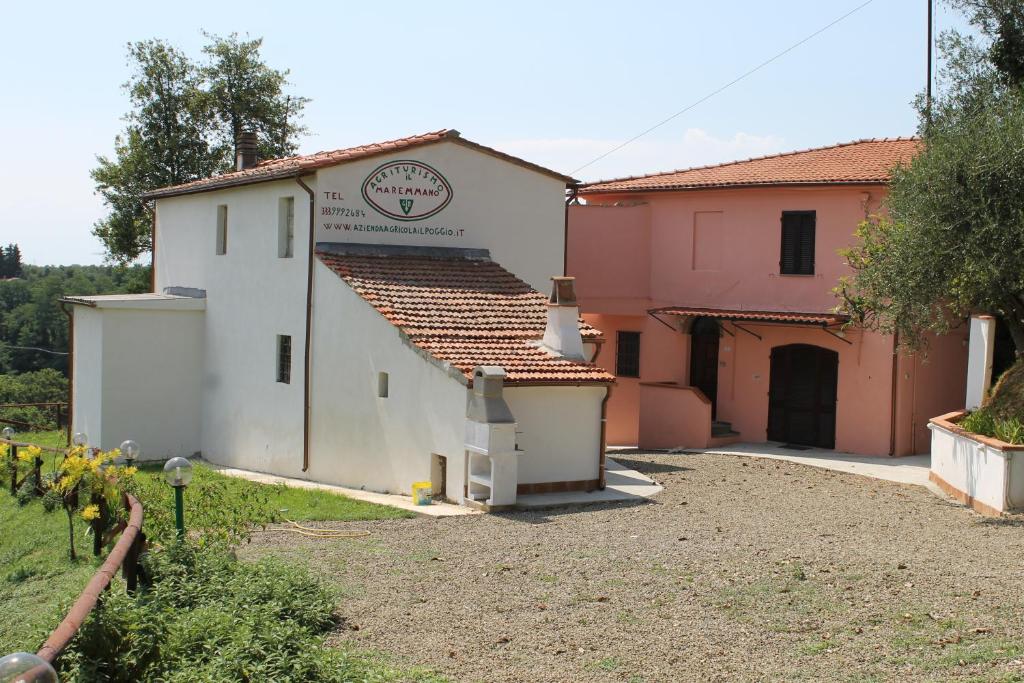 Lari的住宿－Agriturismo Il Maremmano，白色的建筑,上面有标志