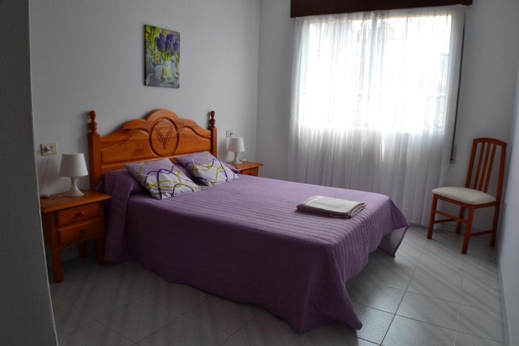 オ・グローベにあるApartamento Rosalía de Castroのベッドルーム1室(紫の毛布と窓付)
