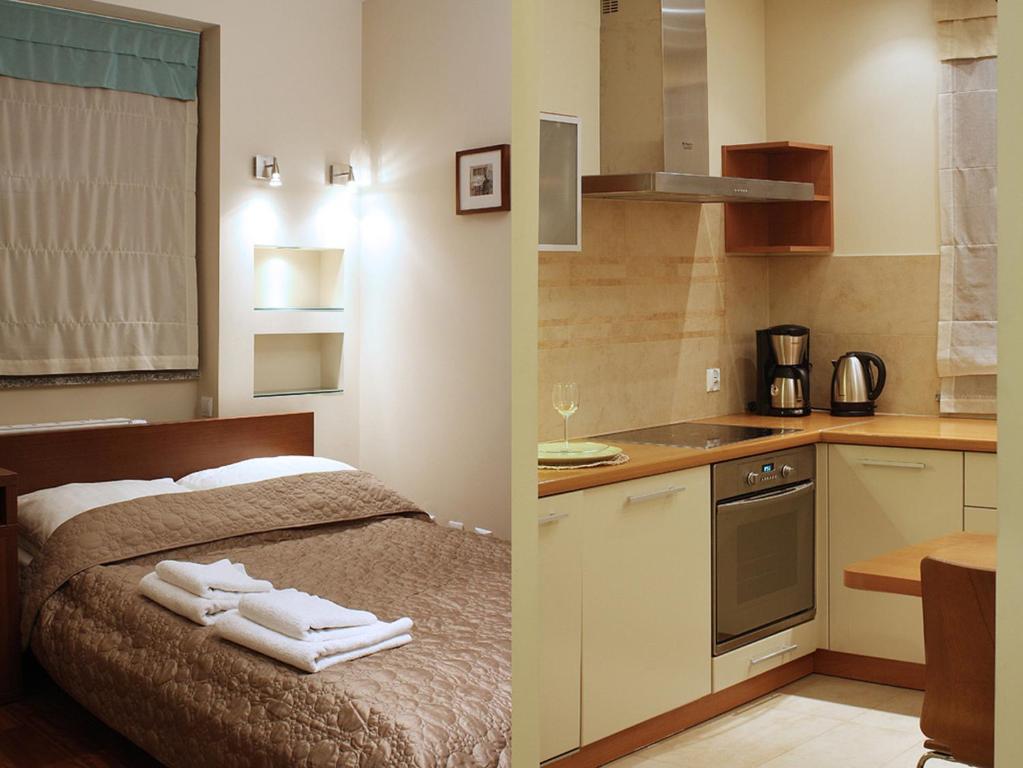 a kitchen and a bedroom with towels on a bed at Apartamenty Junior in Wrocław