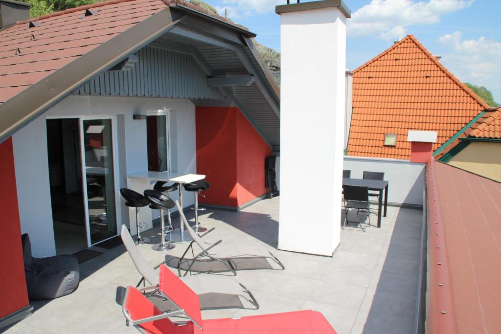 a patio with chairs and tables on a building at Haus am Donausee (House at the Danube Lake Beach) in Weitenegg