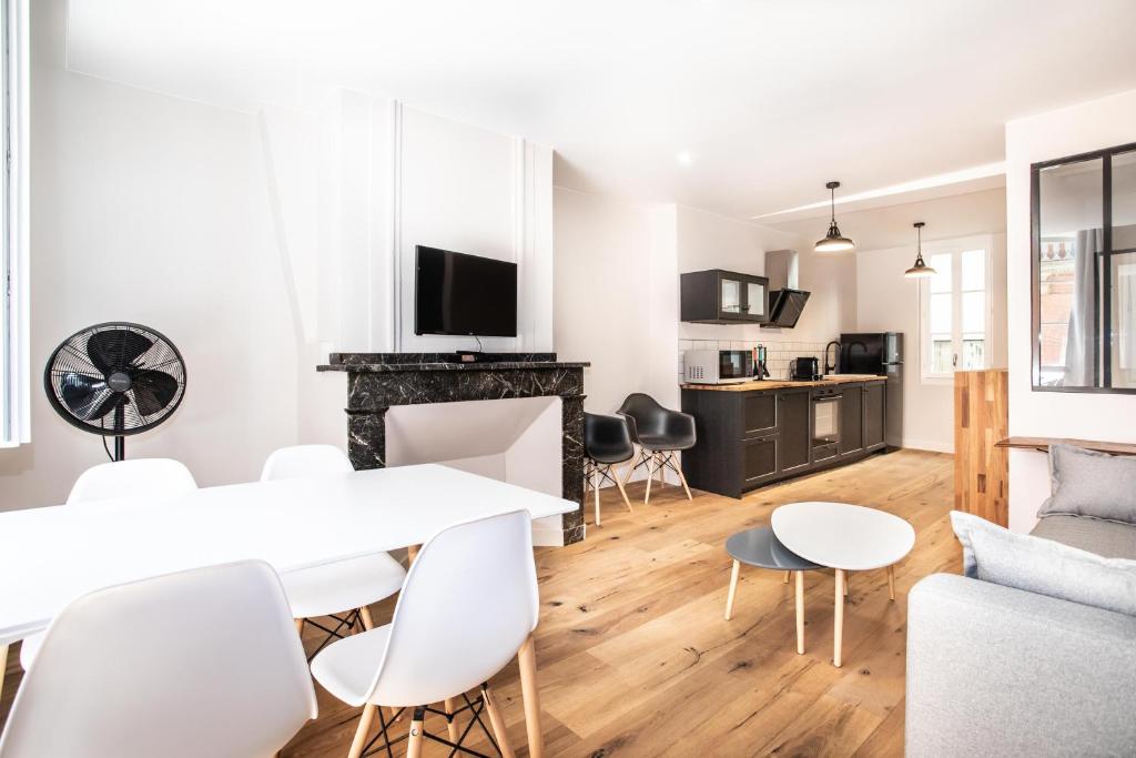 sala de estar y cocina con mesa blanca y sillas en Appartement 4 - Standing, moderne et tout équipé - Carmes, Toulouse, en Toulouse