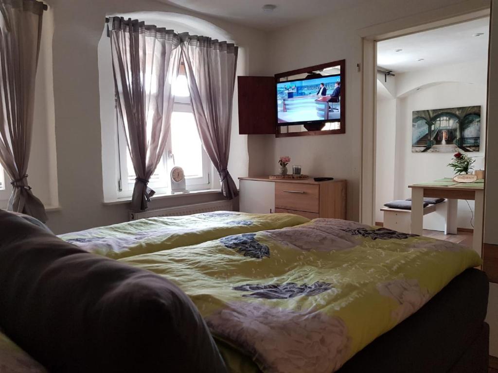 a bedroom with a bed and a flat screen tv at Lindes Ferienwohnung in Dinkelsbühl