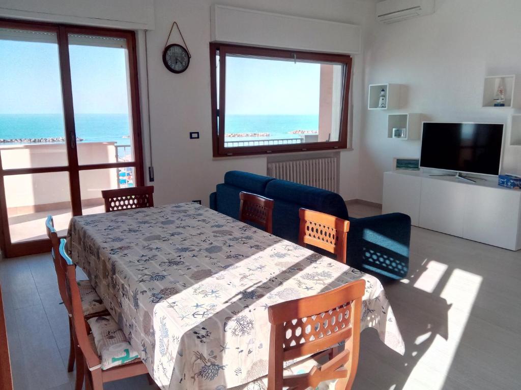 une salle à manger avec une table, des chaises et une télévision dans l'établissement Appartamento Alba Rosa, à Francavilla al Mare