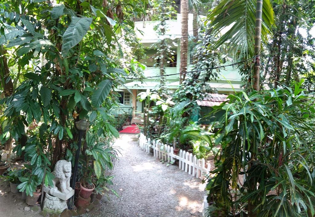 un jardín con muchas plantas y una valla blanca en Green Woods Bethlehem en Kochi