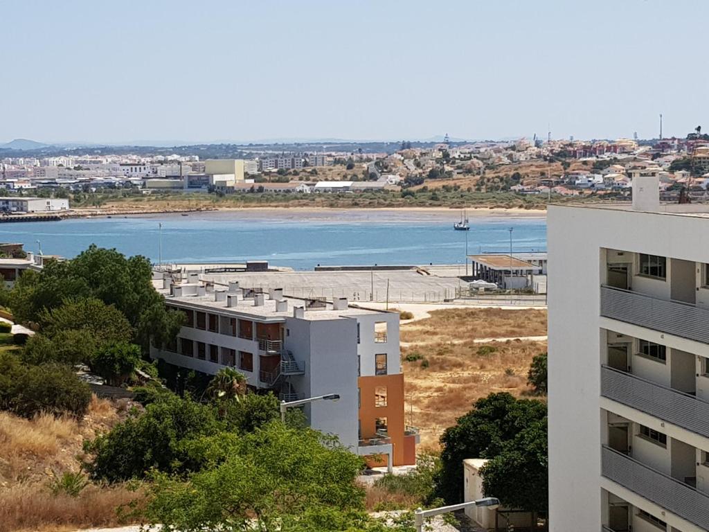 een uitzicht op een gebouw en een waterlichaam bij Encosta da Marina Residence in Portimão