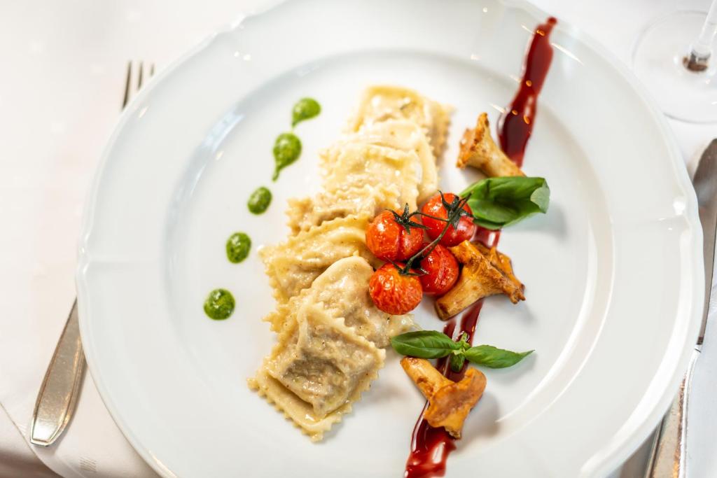 a white plate with food on a table at Hotel Bären in St. Moritz