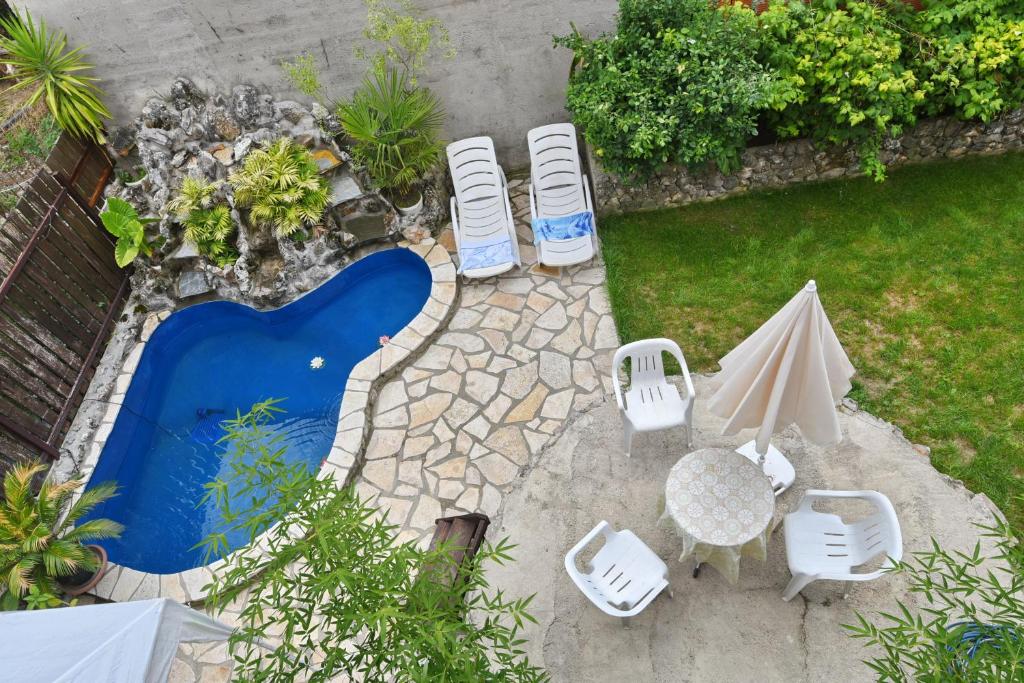 einen Blick über einen Pool mit Stühlen und einem Sonnenschirm in der Unterkunft Pejik apartment in Ohrid