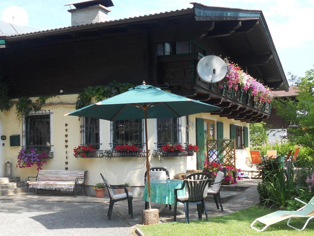 einen Tisch mit einem Regenschirm vor einem Haus in der Unterkunft Haus Lena in Sankt Martin bei Lofer